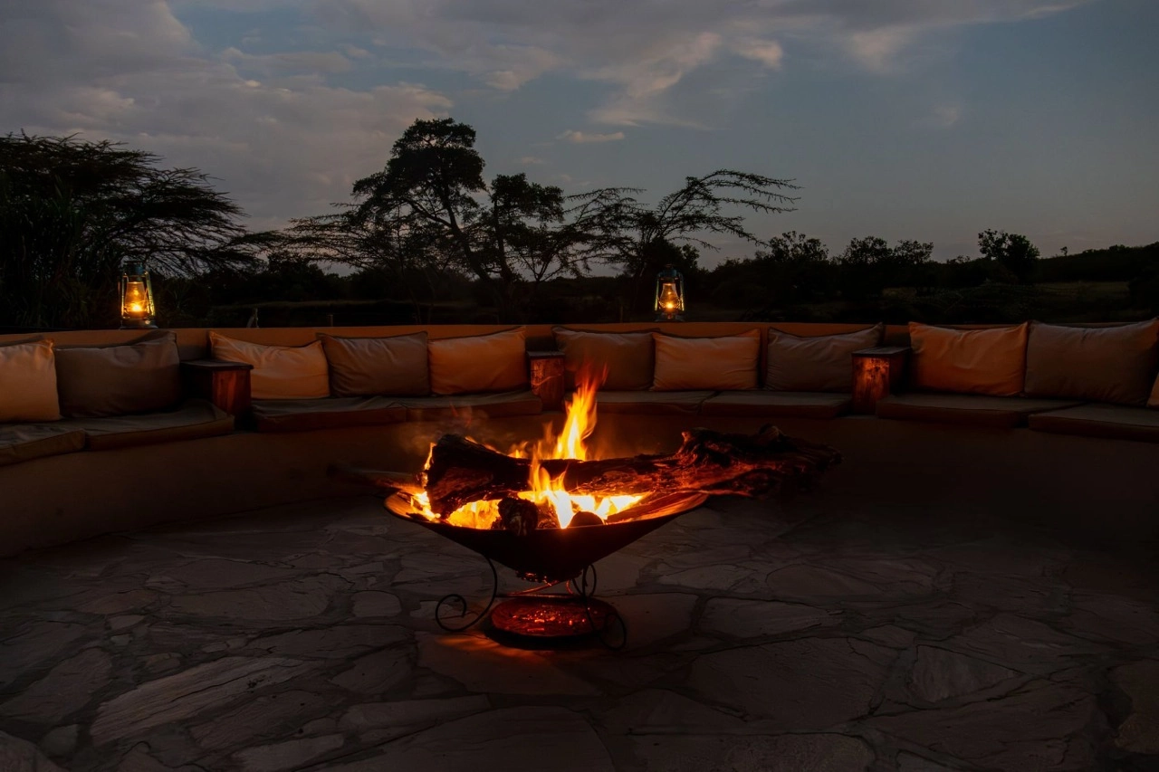 A glowing campfire surrounded by warm lantern light at a South African eco-lodge, illustrating how to plan South Africa eco luxury safari with sustainable, nature-immersive experiences.