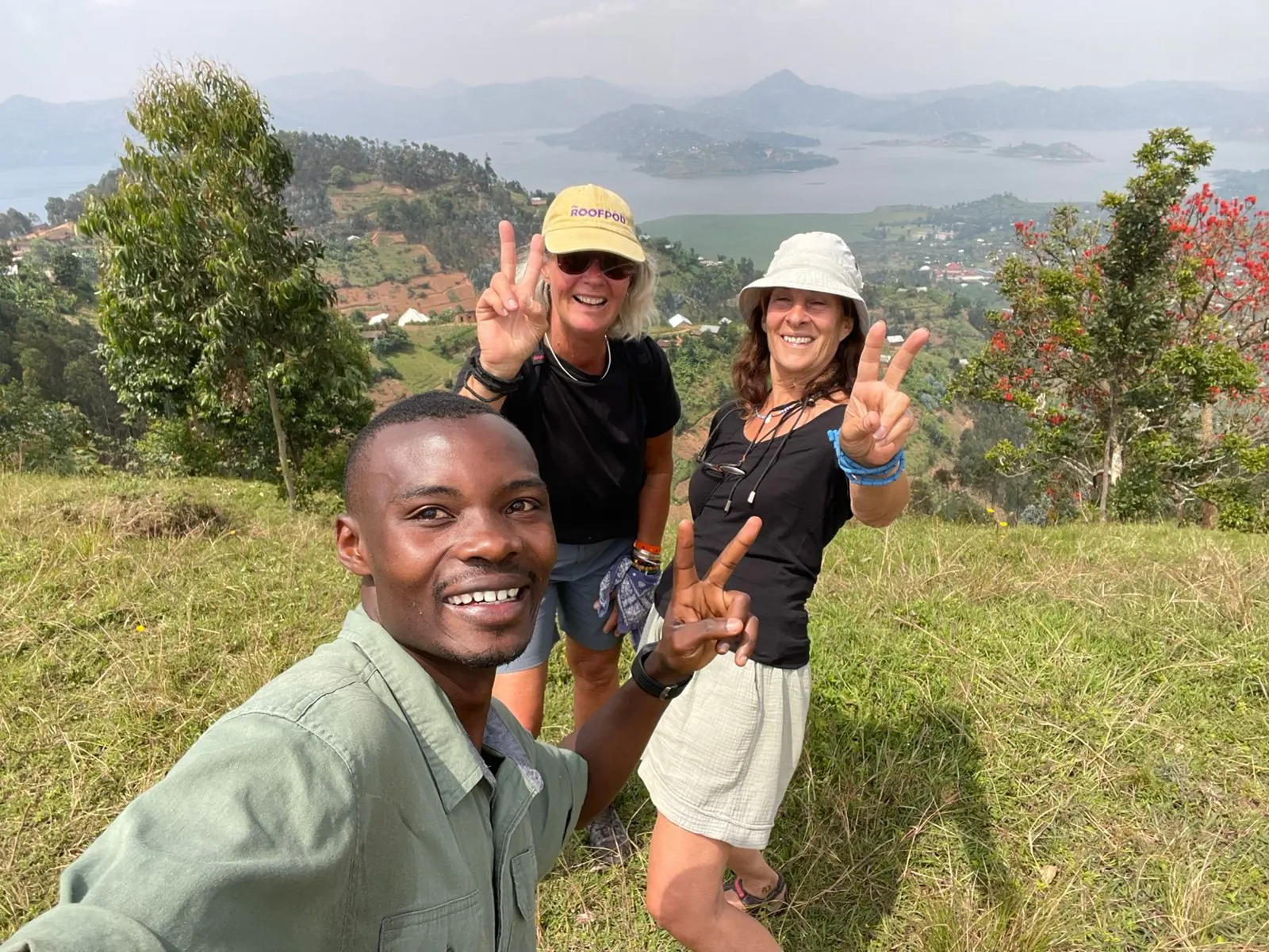 Group Mountain Gorilla Trekking in Rwanda: The Ultimate Safari Experience — travelers hiking with a local guide near Twin Lakes Ruhondo and Burera after a gorilla trek, showcasing Rwanda’s volcanic landscapes and authentic cultural connection.